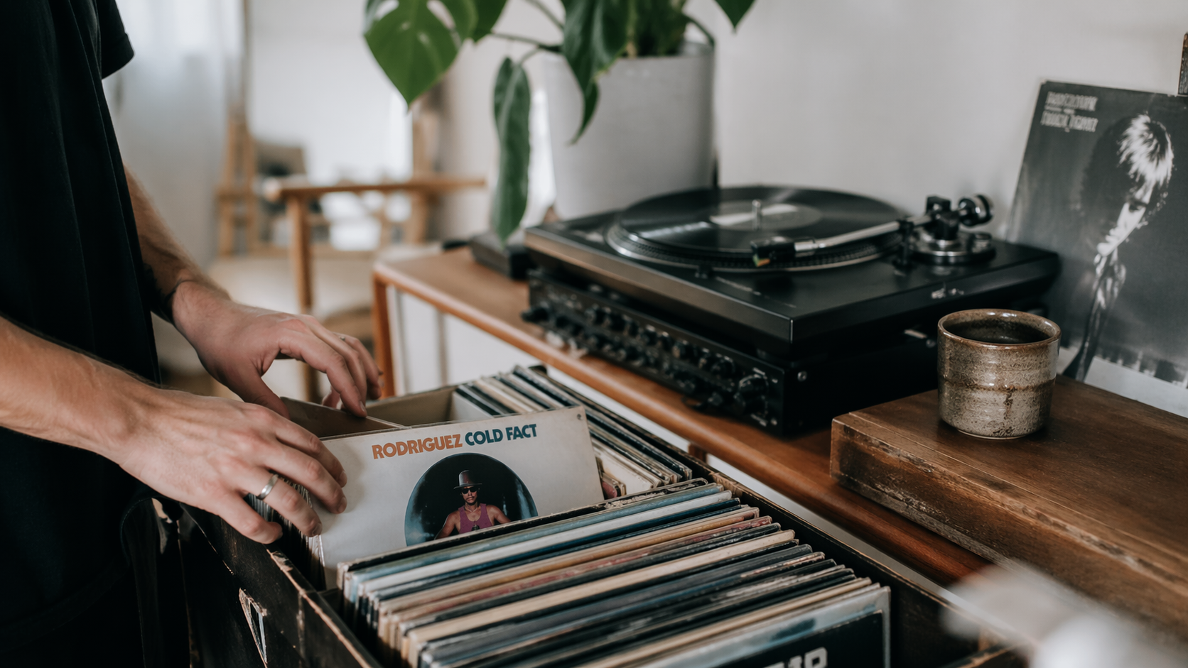 En mann som ser gjennom samlingen sin av vinylplater