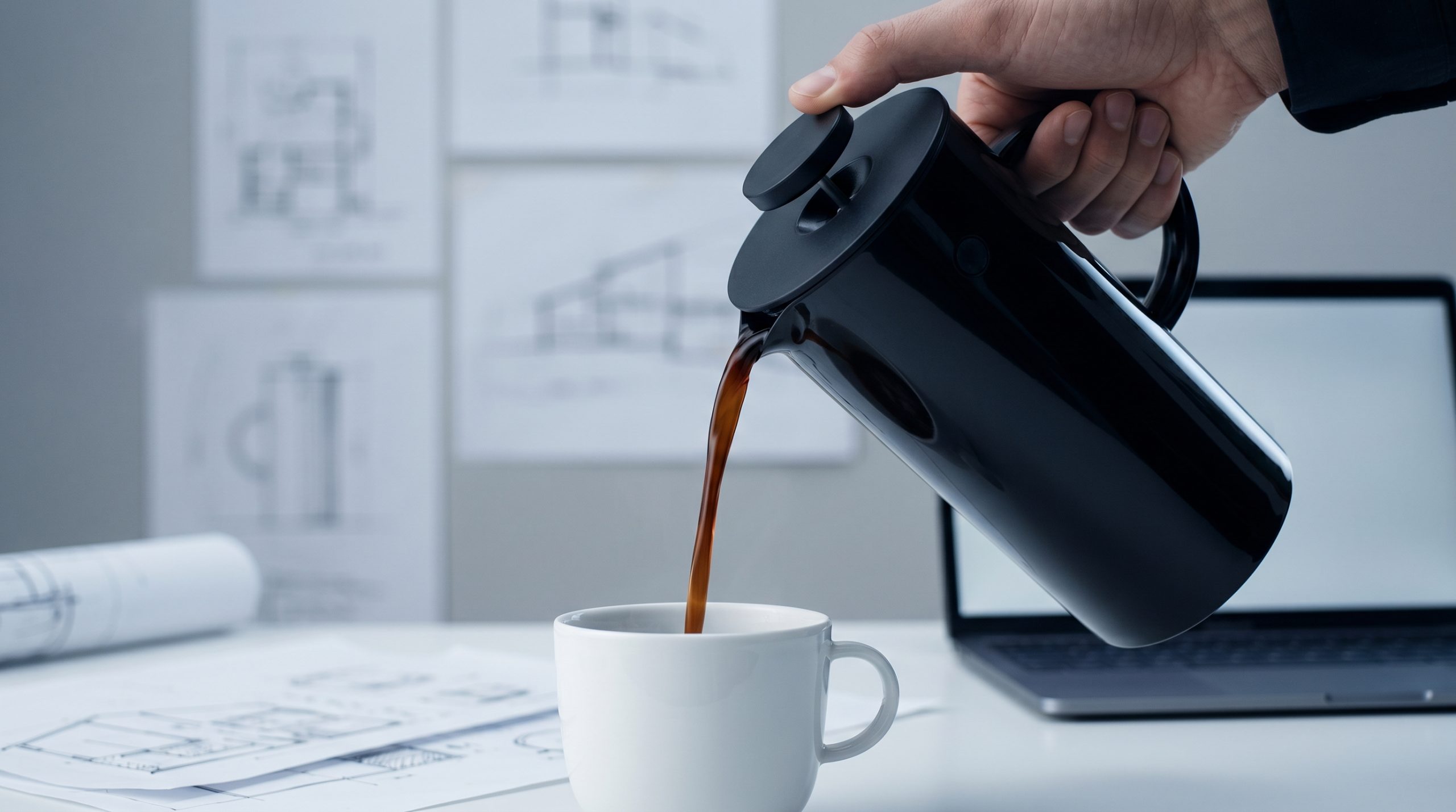 En presskanne som heller kaffe i en kopp på et kontor