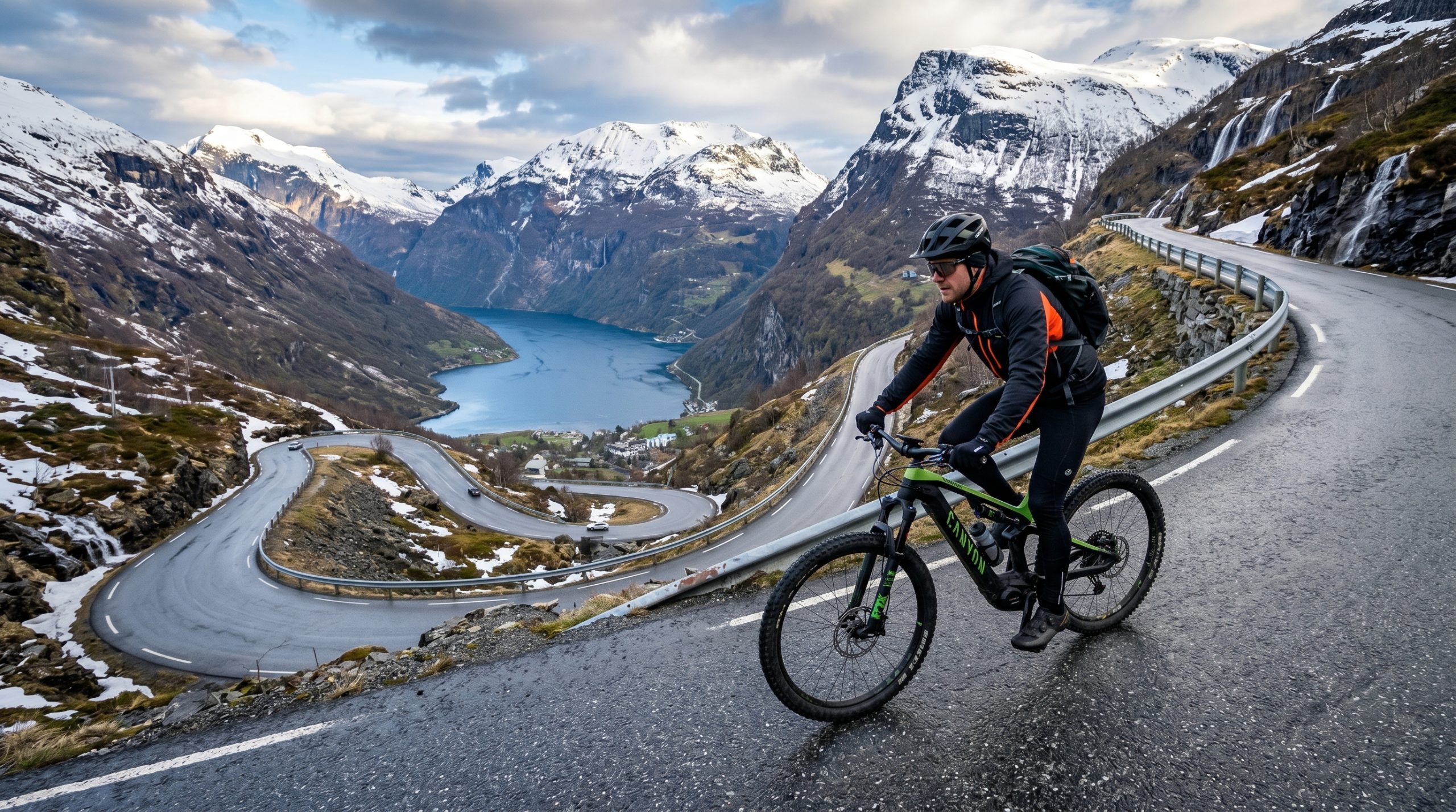En mann på en fjellvei ved en norsk fjord, syklende på en elsykkel.